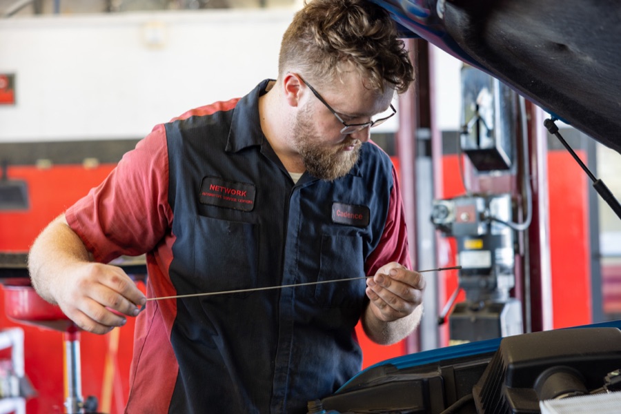 Network Automotive technician working under the hood