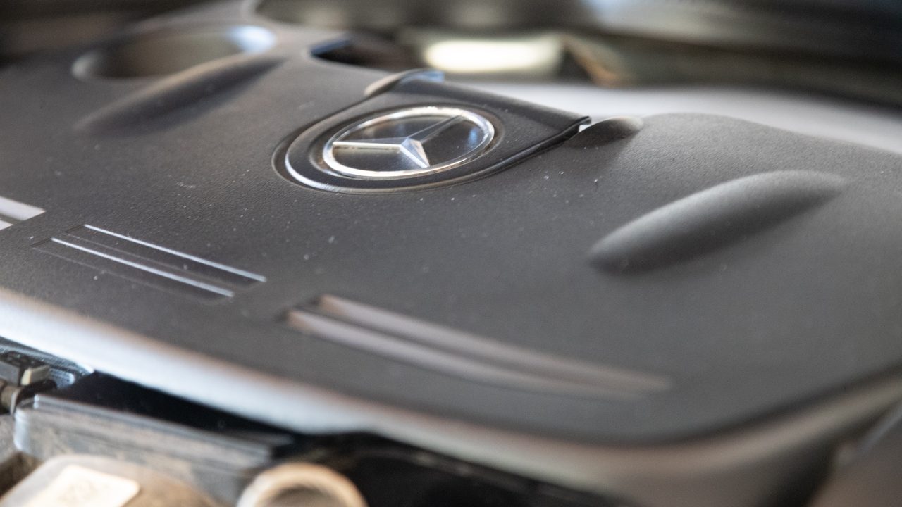 A close-up view of a Mercedes-Benz engine cover inside a vehicle's engine bay