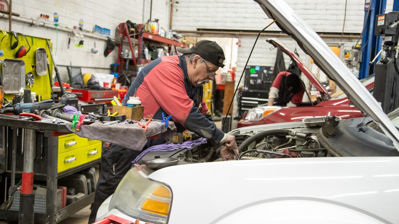 Mechanic working under the hood of a car at Network Automotive