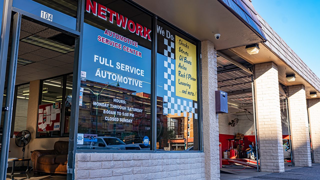 Exterior view of an auto repair storefront with customer lobby windows and open service bays
