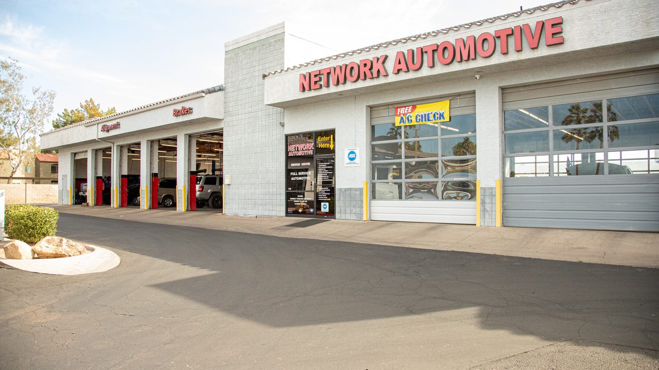 The exterior of an auto repair shop showing multiple service bays with vehicles inside