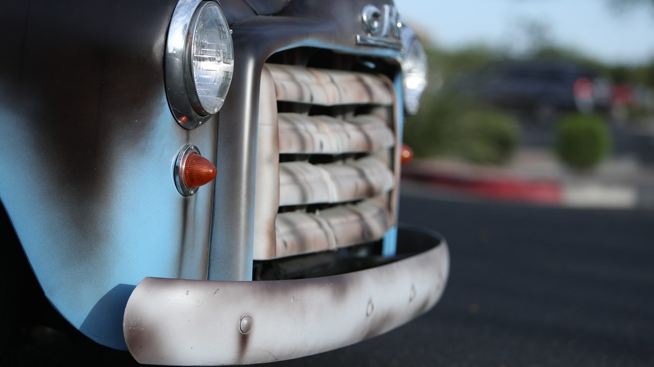 Close-up of the front end, custom grille, bumper, and headlight on a vintage pickup truck