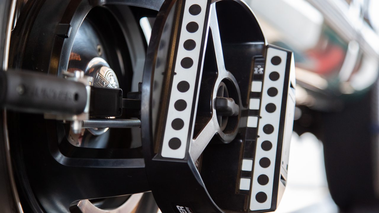 An optical alignment head clamped onto a vehicle wheel during a computerized wheel alignment service