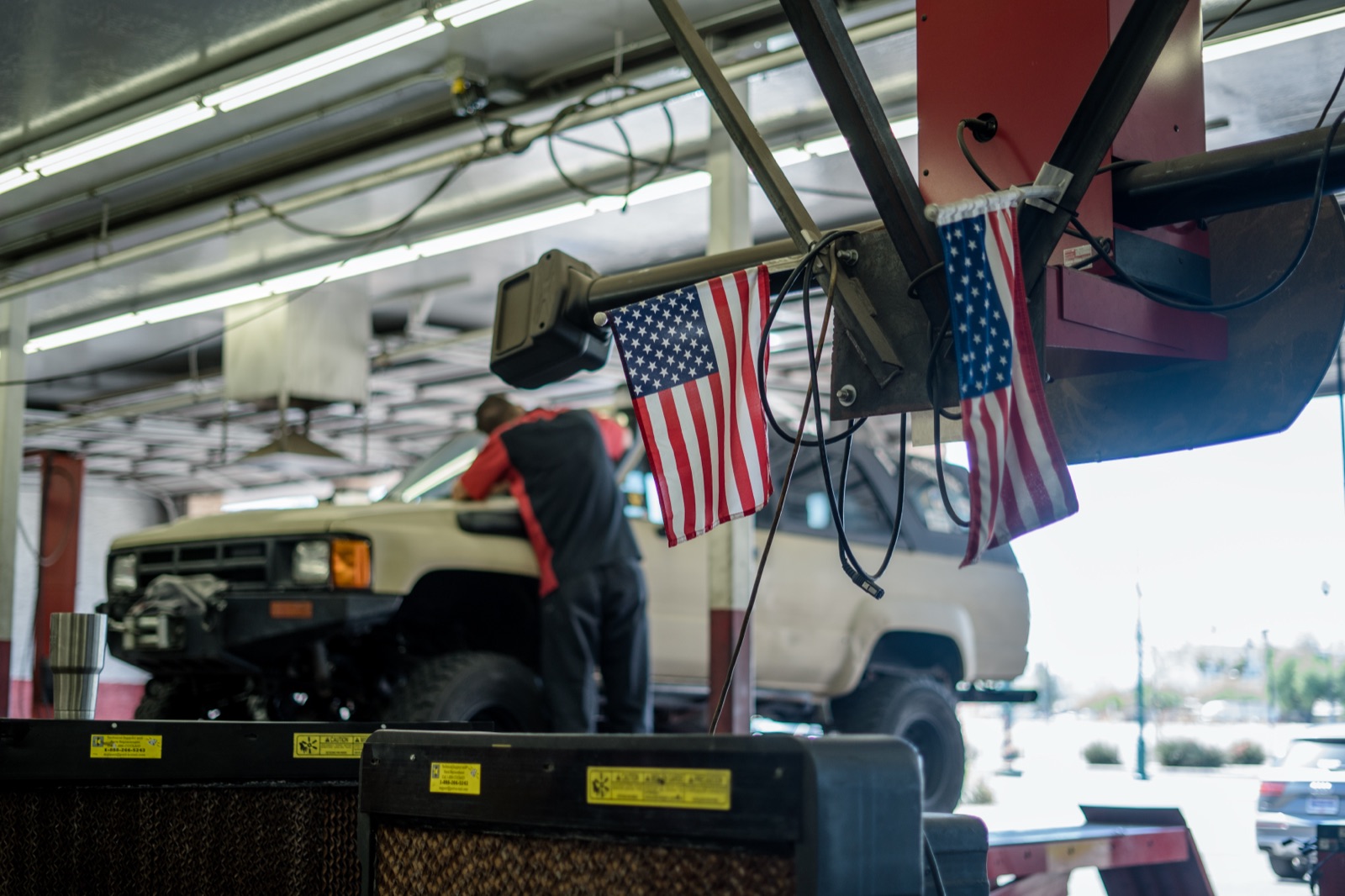 Technician working under a truck in a Network Automotive service bay